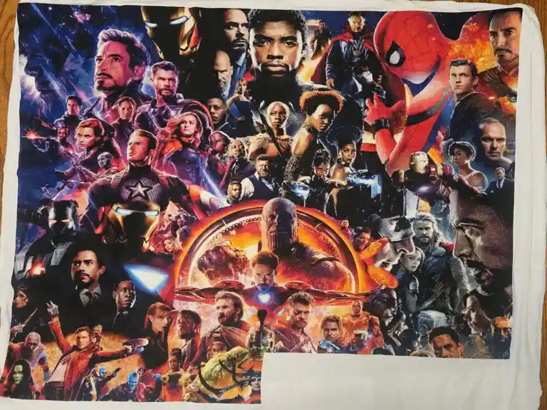 A white towel displays a dense collage of Marvel superhero characters from the 'Avengers: Endgame' movie poster, including…