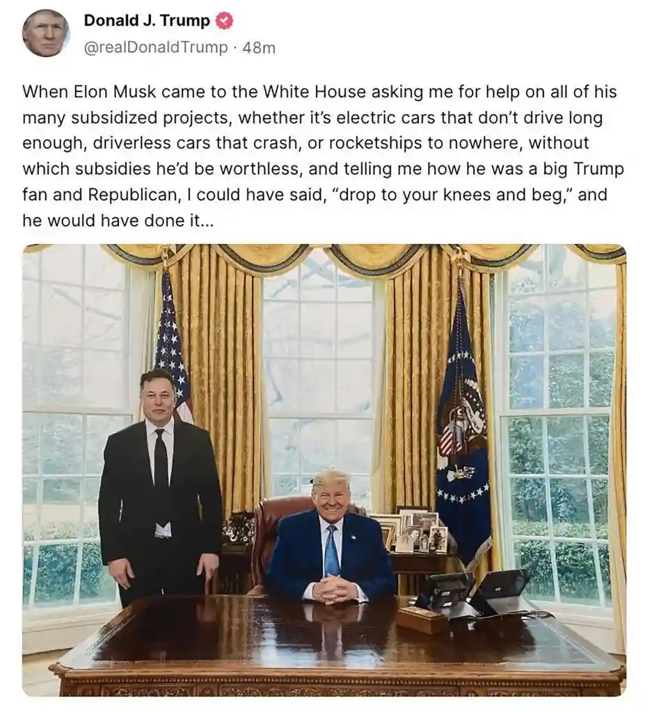 A photo shows Elon Musk standing beside Donald Trump seated at a large wooden desk in the Oval Office, with American flags…