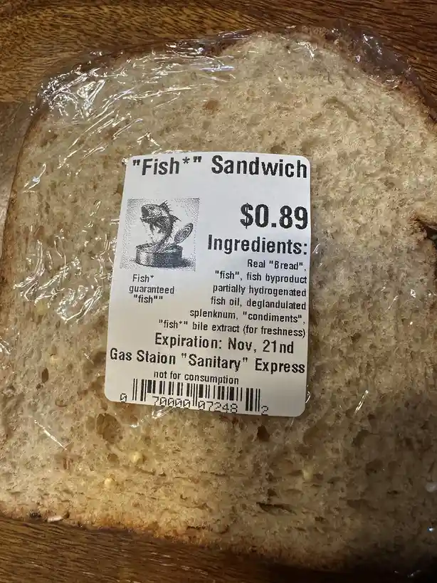 A close-up photo of a sandwich in clear plastic wrap, with a printed label that reads "Fish*" Sandwich, $0.89, and lists…