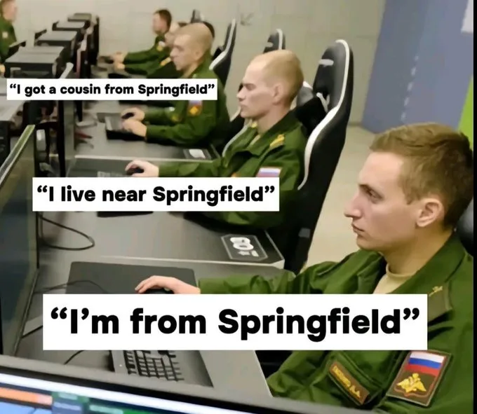 A row of men in green military-style uniforms sit at computer stations, each progressively closer to the camera. Overlaid…