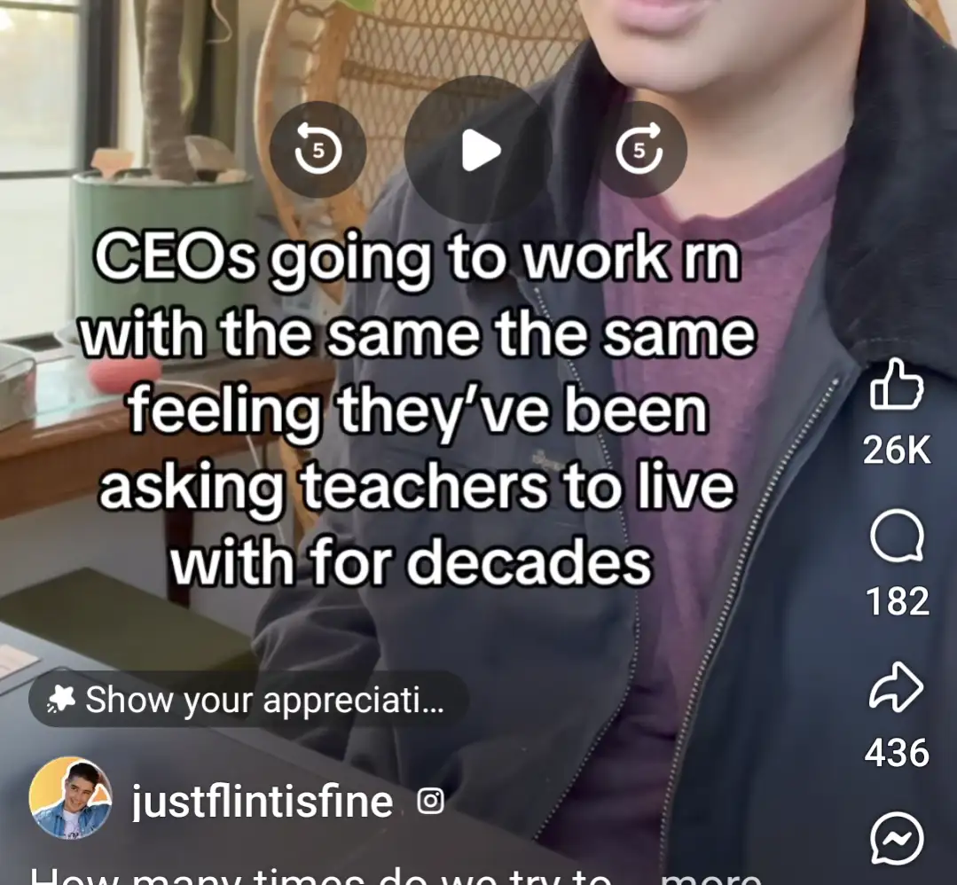 A person in a dark jacket and purple shirt is shown from the chest up in what appears to be a home office setting, with a…