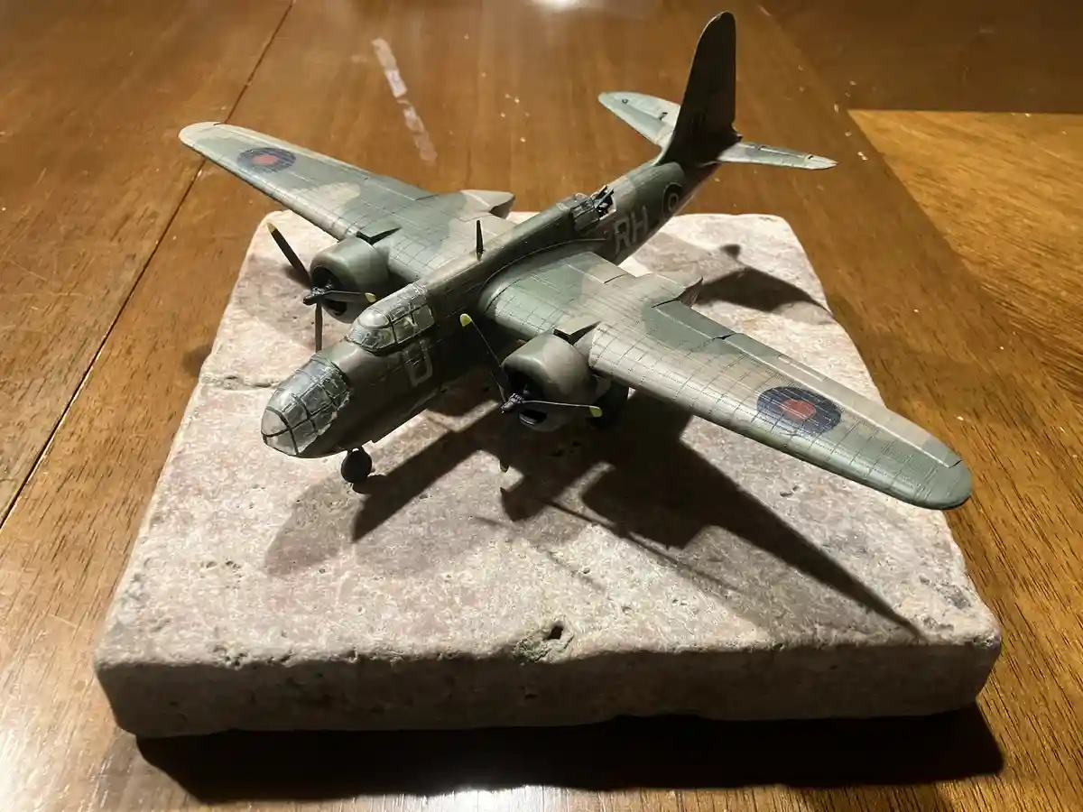 A detailed green and grey model of a WWII-era British bomber aircraft, featuring roundels and 'RH' markings, is displayed on…