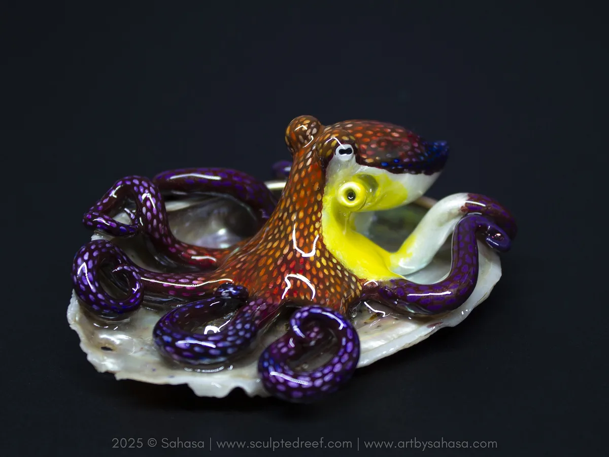 A colorful glass sculpture of an octopus with a brown body covered in orange and red spots, purple tentacles with blue dots…