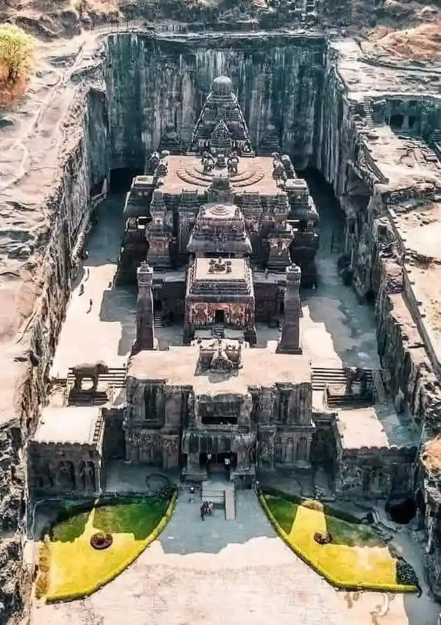 an aerial view of the ancient Kailashnath Temple at Ellora, carved entirely from a single rock cliff, with intricate…
