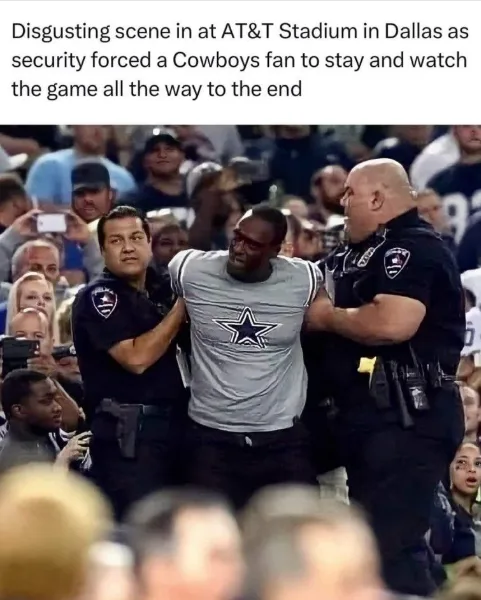 Two police officers are physically escorting a man wearing a Dallas Cowboys t-shirt through a crowded stadium crowd. The man…