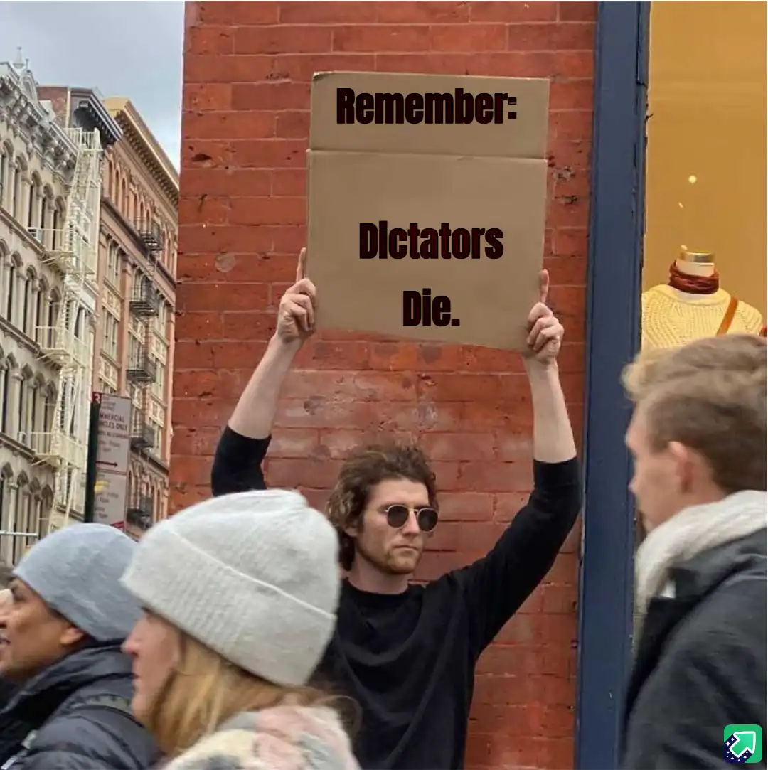 A man with curly hair and sunglasses holds up a cardboard sign that reads 'Remember: Dictators Die.' in front of a red brick…