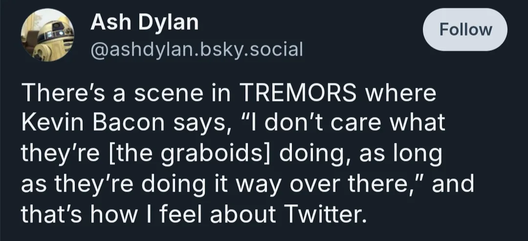 A screenshot of a Twitter post by Ash Dylan (@ashdylan.bsky.social) with a dark background and white text. The post…