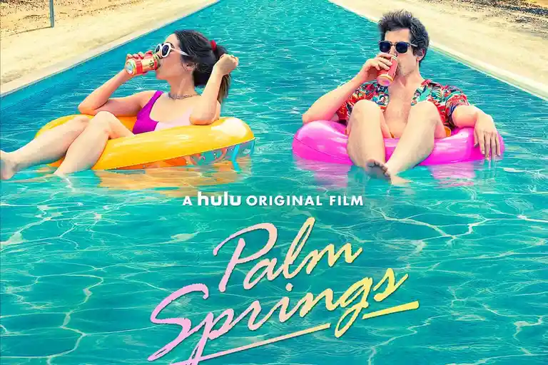 Two people, a woman in a purple swimsuit and a man in a colorful shirt, float in a pool on inflatable rings while drinking…