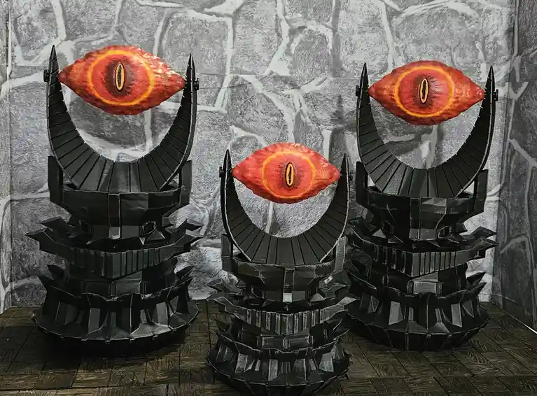 Three black, angular, papercraft-style statues resembling demonic or fantasy creatures, each topped with a large, glowing…