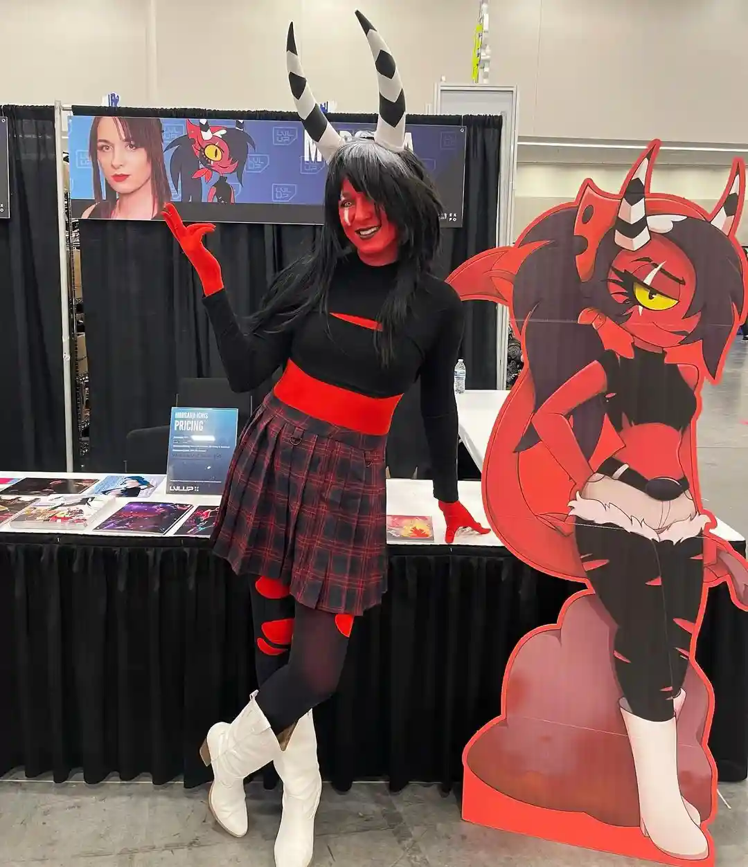 A person in a detailed cosplay of the animated character Morsana, complete with black and red outfit, white horns, and red…
