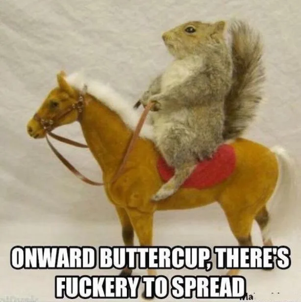 A real-life squirrel is perched atop a small, toy horse with a red saddle and white mane, holding the reins. The image has…