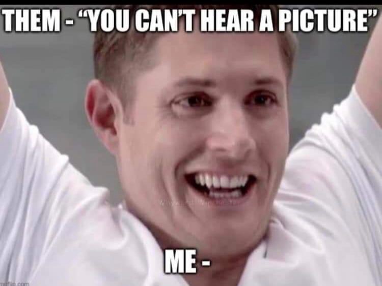 A close-up image of actor Jensen Ackles smiling broadly with his arms raised, wearing a white t-shirt. The text overlay…