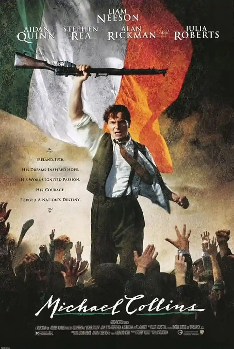 A movie poster for 'Michael Collins' shows Liam Neeson holding a rifle aloft against a backdrop of the Irish flag, standing…