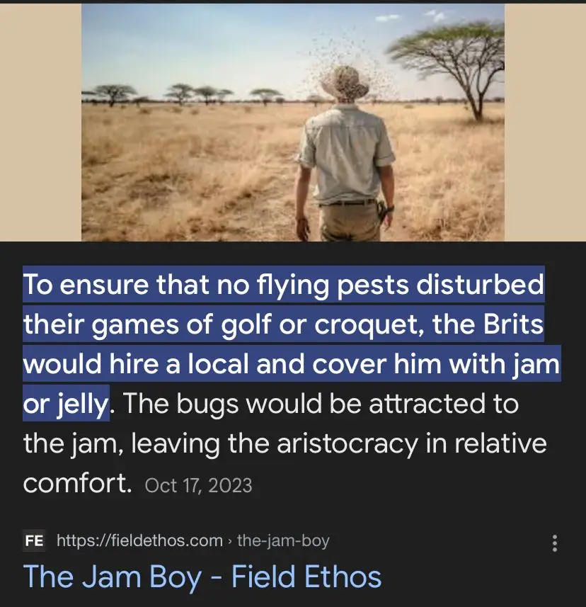 A man in a safari hat and shirt stands with his back to the camera in a dry, grassy savanna, facing away from the viewer. A…