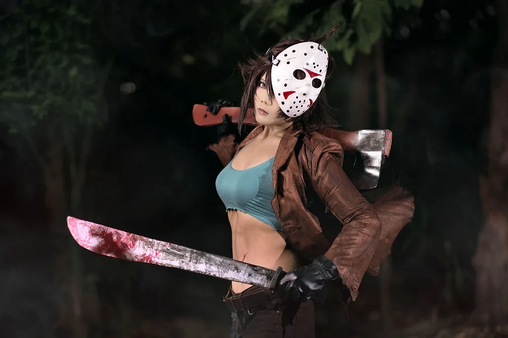 a woman in a Jason Voorhees-style hockey mask and brown leather jacket stands in a dark forest, holding a large bloody…