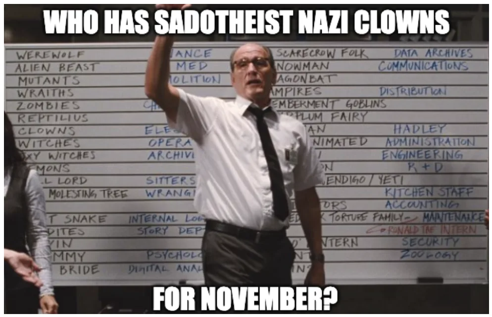 A man in a white shirt and black tie stands in front of a whiteboard filled with handwritten department names like…