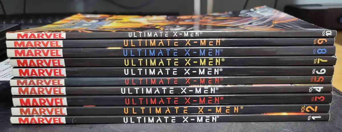 A stack of ten Marvel 'Ultimate X-Men' comic book volumes, numbered 1 through 10 from bottom to top, with the title…