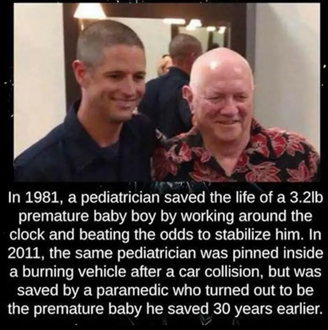 Two men are smiling at the camera, one younger with a buzz cut and dark shirt, the other older and bald wearing a floral…