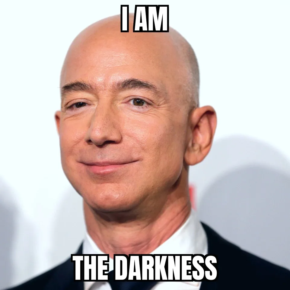 A close-up photo of Jeff Bezos, a bald man in a dark suit and white shirt, smiling slightly with a neutral expression. The…