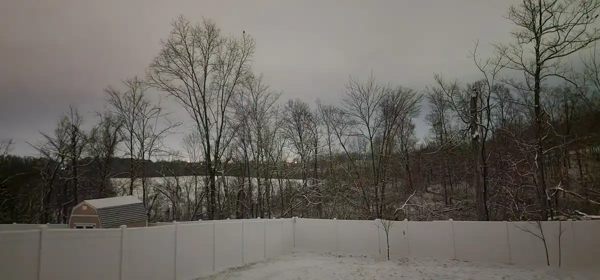 A snowy backyard scene with a white fence, bare trees, and a shed under an overcast sky, overlaid with the text 'i'm not…