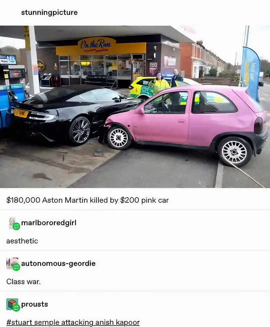 A black Aston Martin sports car is visibly damaged in a collision with a small, cheap-looking pink car at a gas station. The…