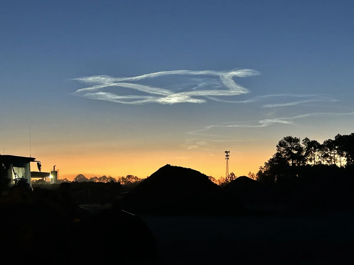 A serene twilight photo shows a sky with a distinct, wispy cloud formation that resembles the iconic 'it's a bird, it's a…