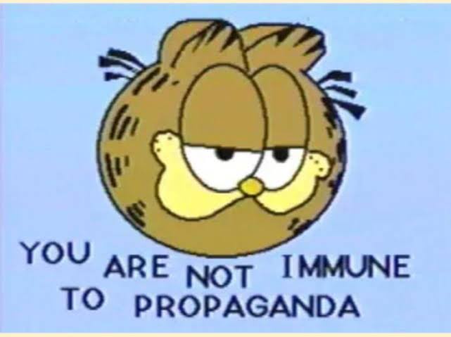 A cartoon image of Garfield, the orange tabby cat, with a tired, unimpressed expression and droopy eyes, set against a plain…