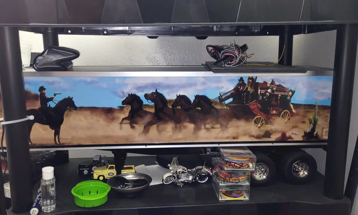 A wide, horizontal painting depicting a classic Western scene with a lone cowboy on horseback aiming a gun at a stagecoach…