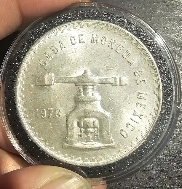 A close-up photo shows a silver Mexican coin from 1978, held in a clear protective case, with the text 'CASA DE MONEDA DE…