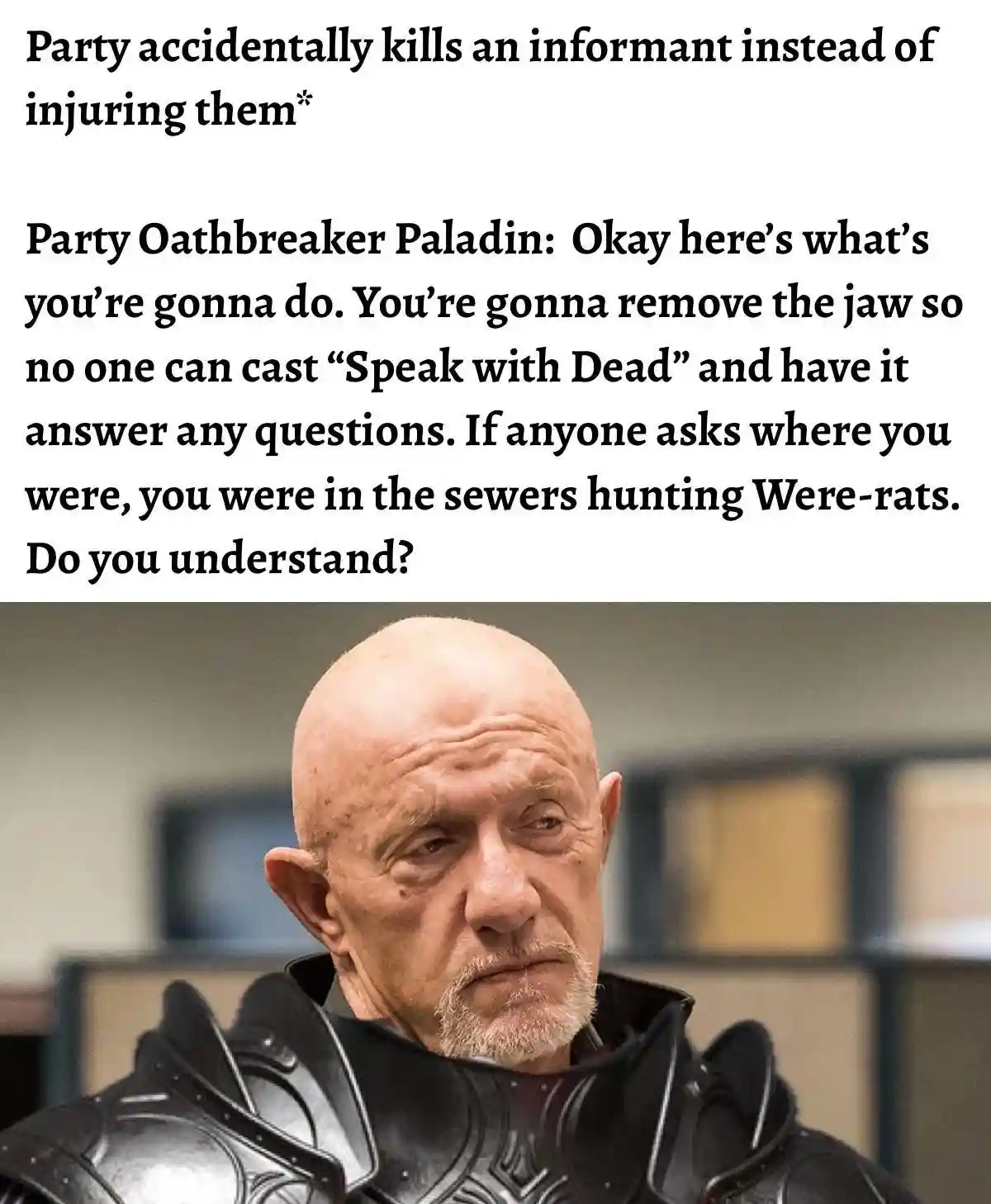The image shows a bald, bearded man in dark armor with a stern, unimpressed expression, set against an office background…