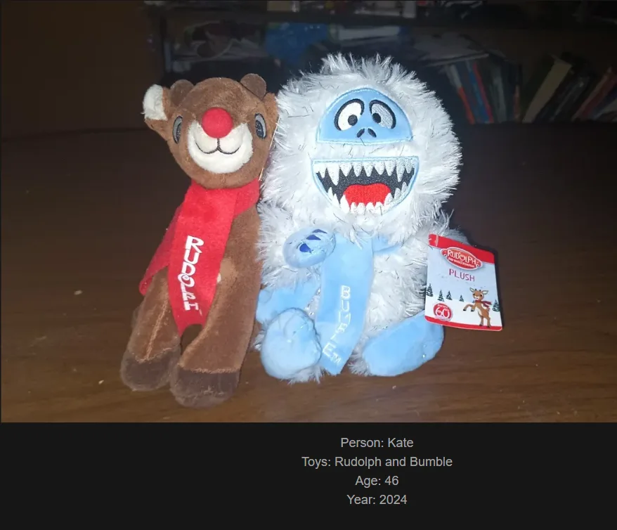 Two plush toys, Rudolph the red-nosed reindeer and Bumble the yeti, sit side by side on a wooden surface. Rudolph wears a…