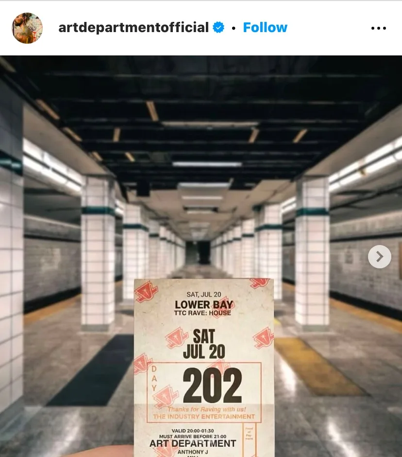 A hand holds a concert ticket for 'Art Department' at 'Lower Bay TTC Rave: House' on July 20, 202, with a blurred subway…