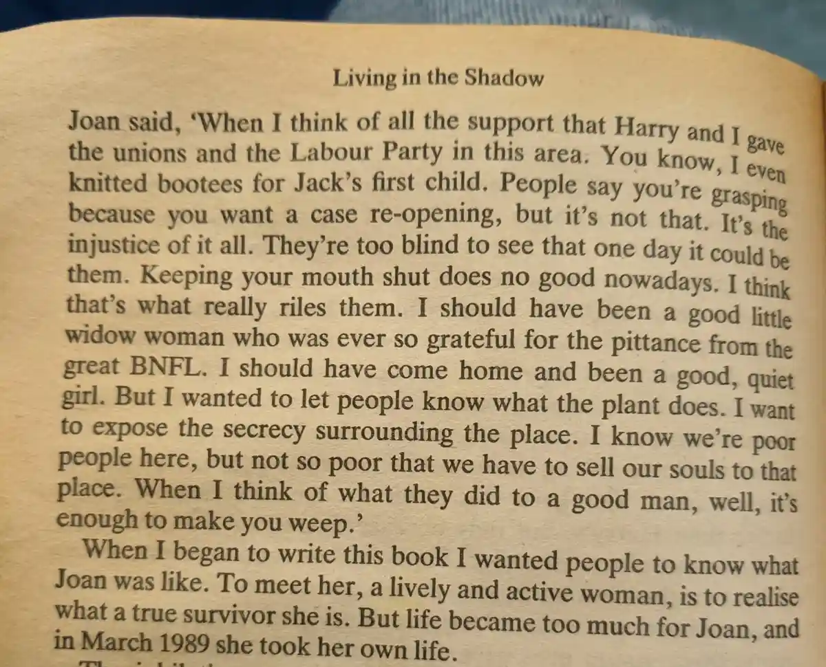 A close-up photo of a book page titled 'Living in the Shadow,' showing a passage where Joan recounts her activism, her grief…