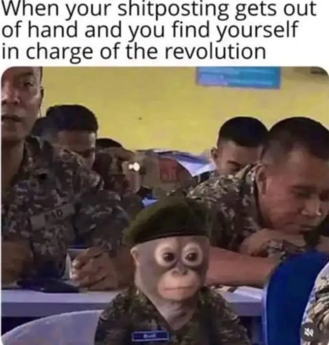A photo shows a small monkey wearing a military uniform and beret, sitting at a desk in a classroom with other soldiers. The…