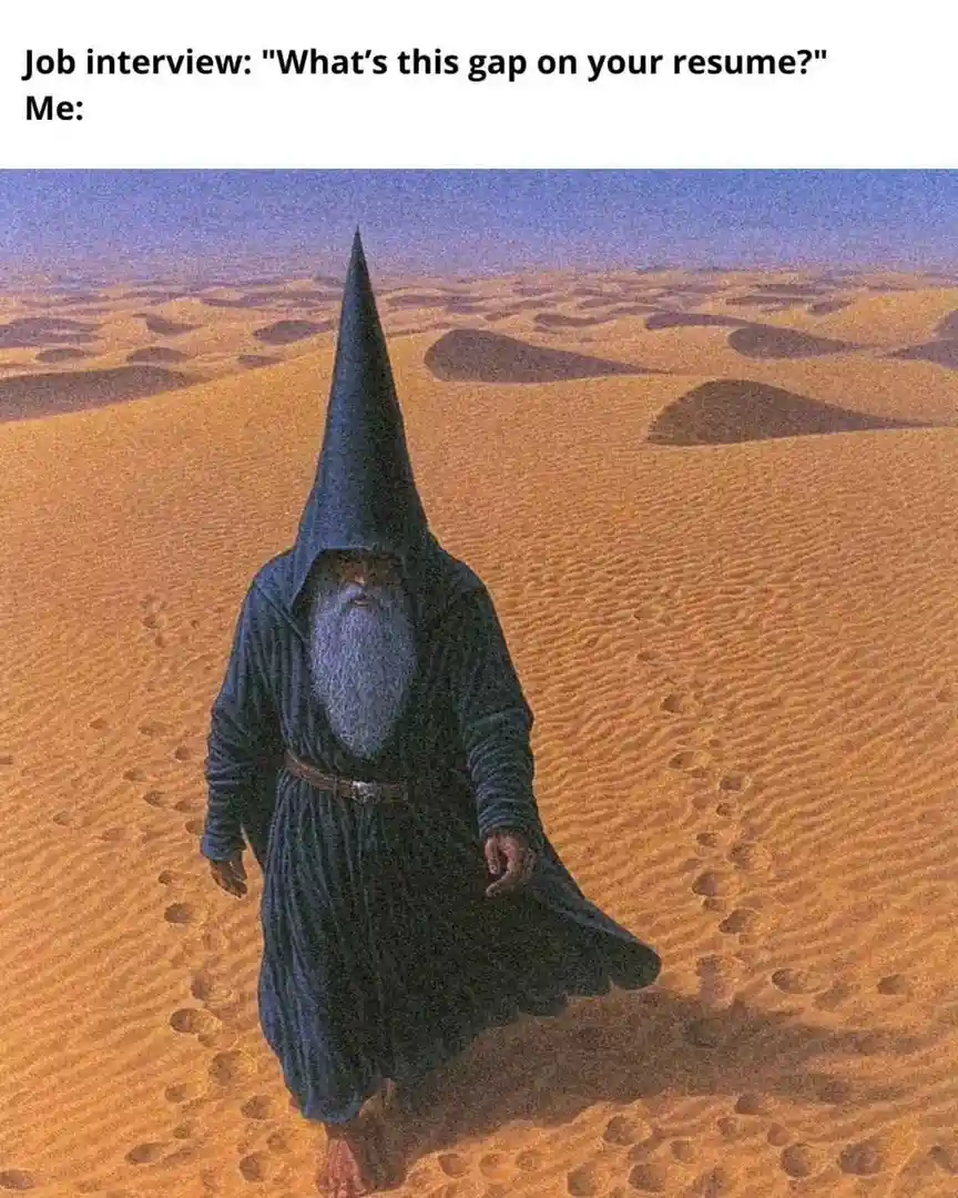 A painting depicts a bearded man in a dark blue, pointed hooded robe walking barefoot across a vast desert, leaving…