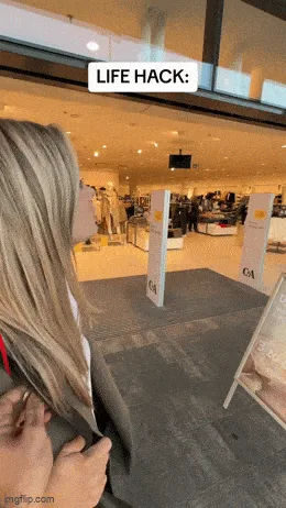 A woman tries on a coat in a clothing store, then walks away holding it. The sequence ends with a red balloon floating in…