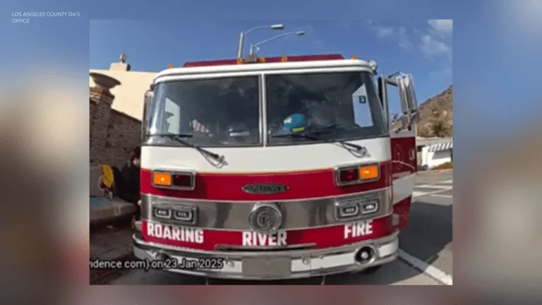 A red and white fire truck with 'ROARING RIVER FIRE' written across the front bumper is parked outdoors under a clear blue…