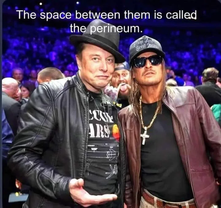 Two men stand side-by-side in a crowded event, both wearing leather jackets and hats. The man on the left wears a black…