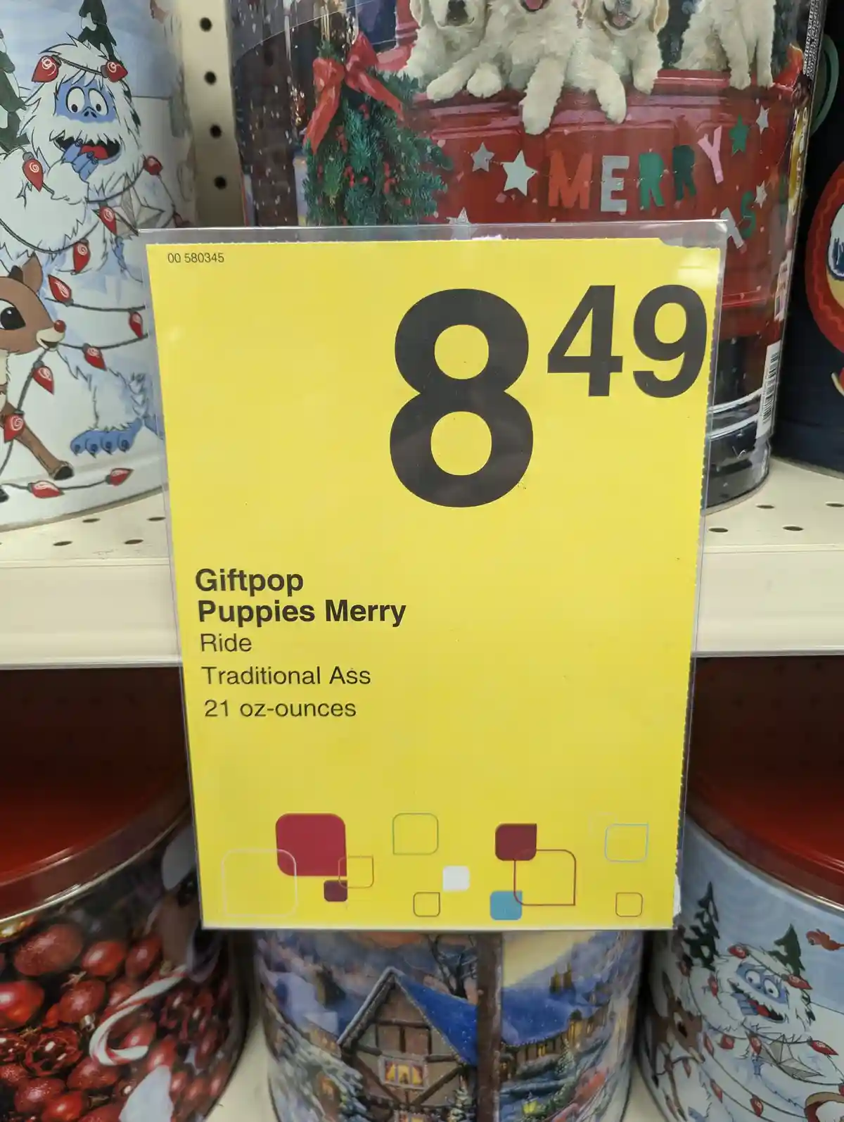 A yellow price tag on a store shelf shows the price $8.49 for a product labeled 'Giftpop Puppies Merry Ride Traditional Ass…