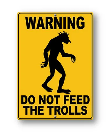 A yellow rectangular warning sign with black text and a black silhouette of a troll-like creature. The top text reads…