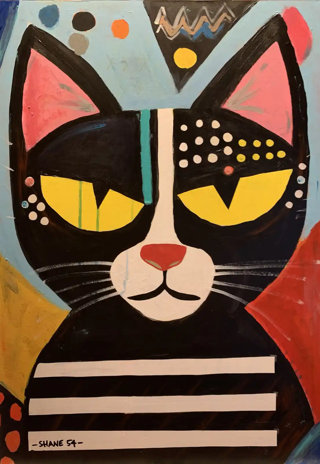 A stylized, colorful painting of a black cat's face with pink inner ears, yellow eyes, and a white muzzle, set against a…