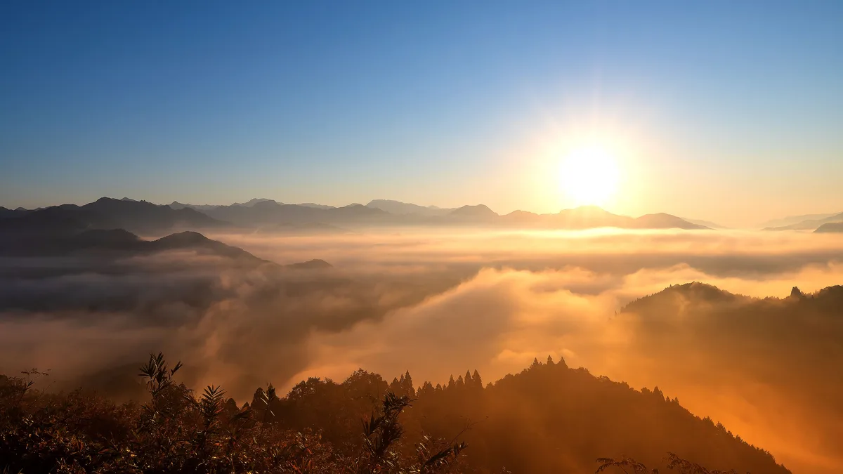 In this Japanese daybreak scene, the sun is highlighted above the misty Takachiho Gorge, a breathtaking river-carved marvel…