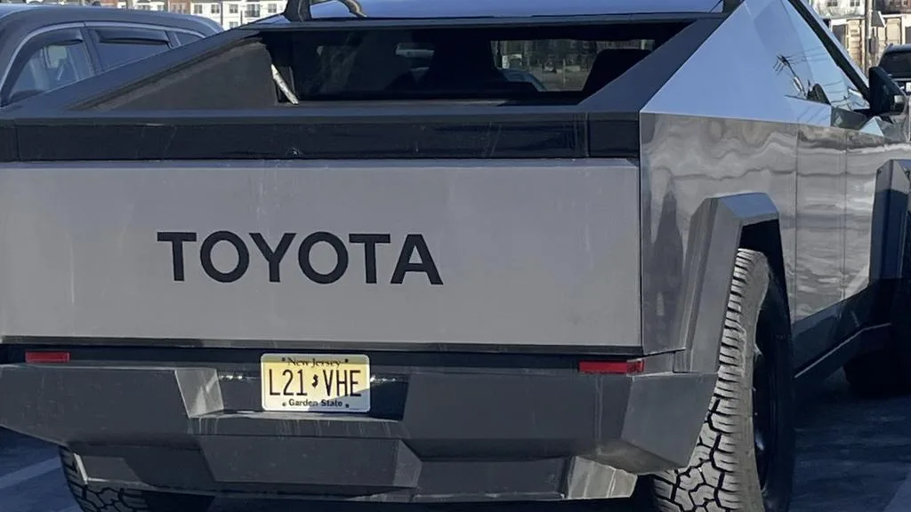 The rear view of a silver, angular, futuristic-looking pickup truck with 'TOYOTA' written in large black letters on the…