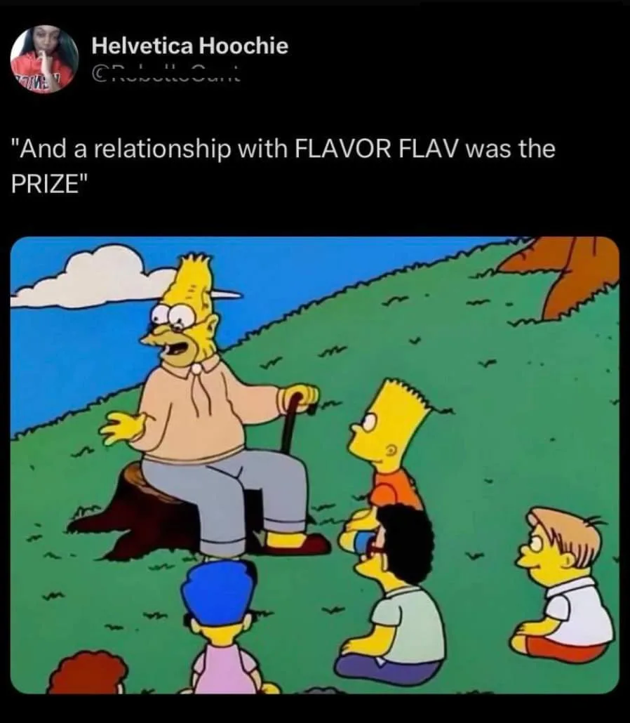 An older, balding, bespectacled Bart Simpson sits on a tree stump outdoors, gesturing animatedly while speaking to a group…