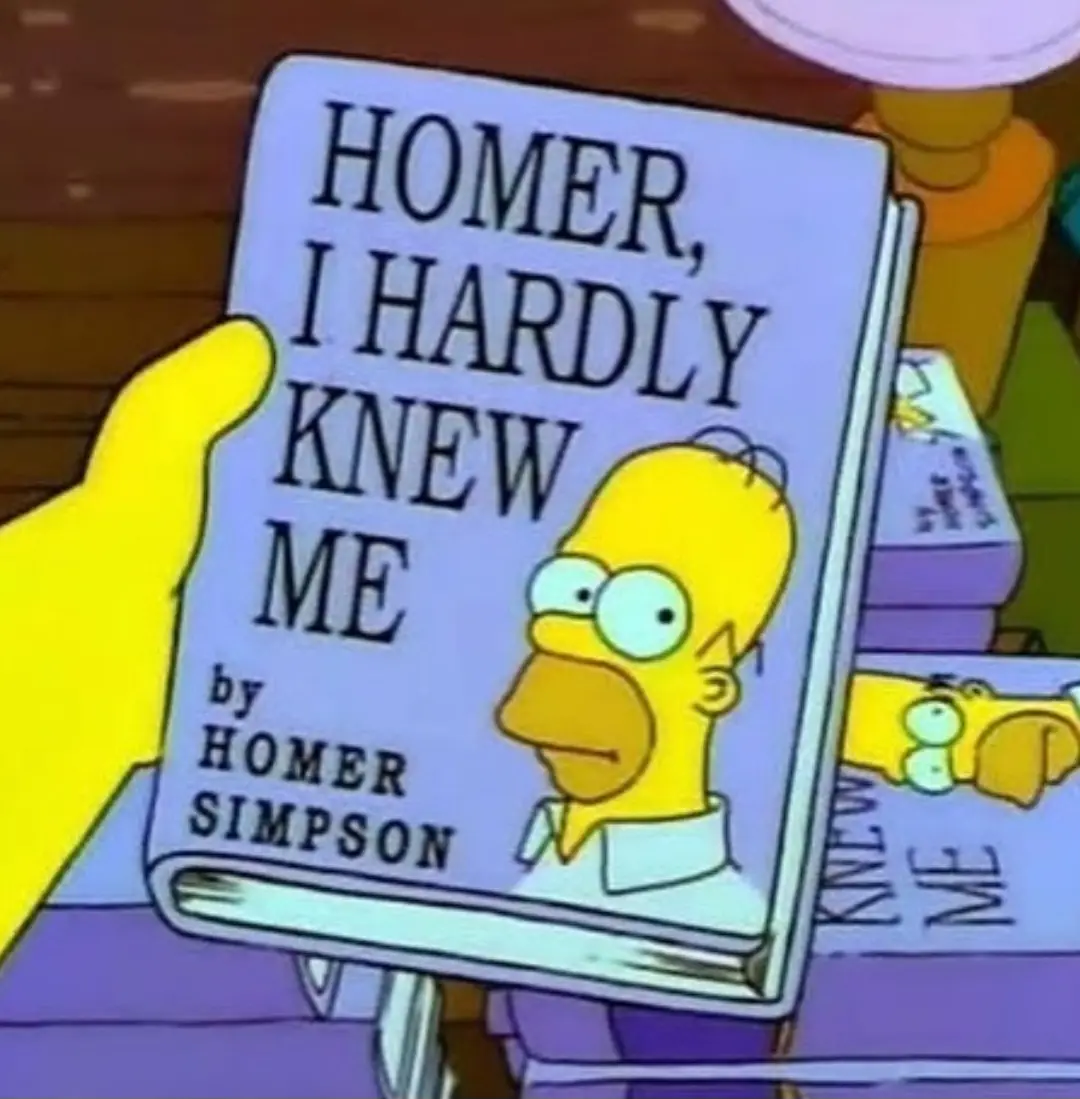 A yellow-skinned cartoon hand holds a book titled 'HOMER, I HARDLY KNEW ME' by HOMER SIMPSON, featuring a portrait of Homer…