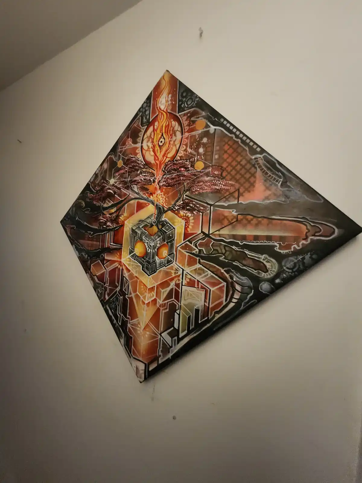 A diamond-shaped, abstract painting hangs on a plain wall, featuring a central glowing cube with orange orbs, a fiery eye…
