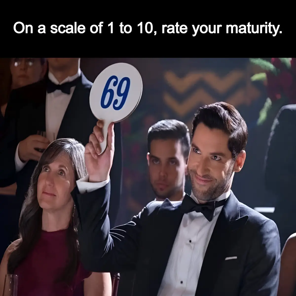 A man in a tuxedo holds up a paddle with the number 69 on it at what appears to be a formal event, while the text above asks…