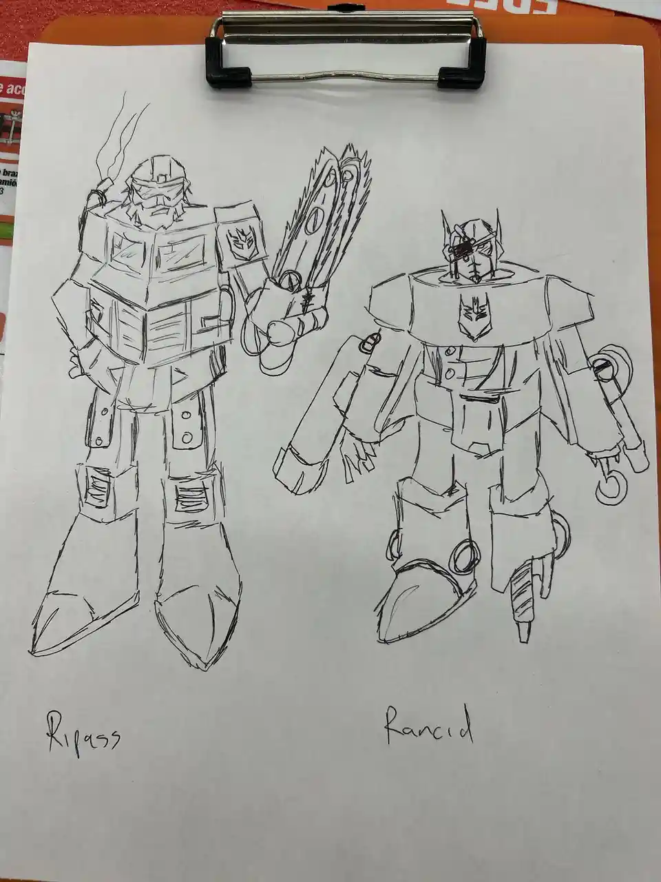 A hand-drawn sketch on paper shows two robot characters, labeled 'Ripass' and 'Rancid', both resembling Transformers. Ripass…