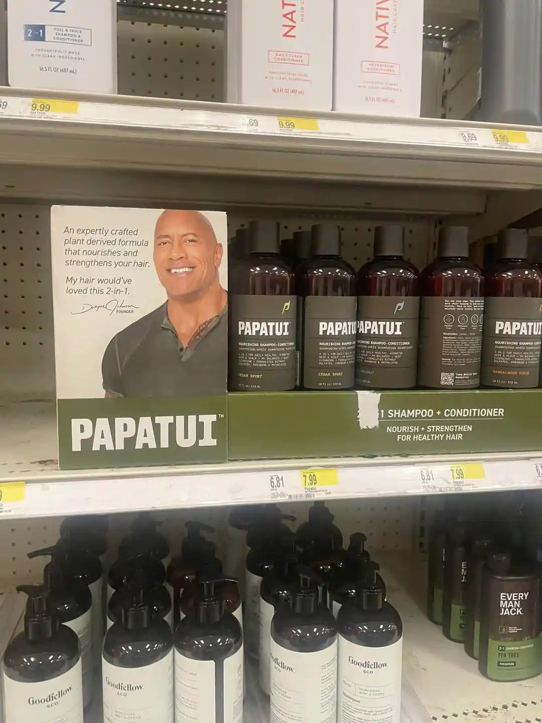 A store shelf displays PAPATUI 2-in-1 shampoo and conditioner bottles next to a product box featuring a smiling Dwayne…