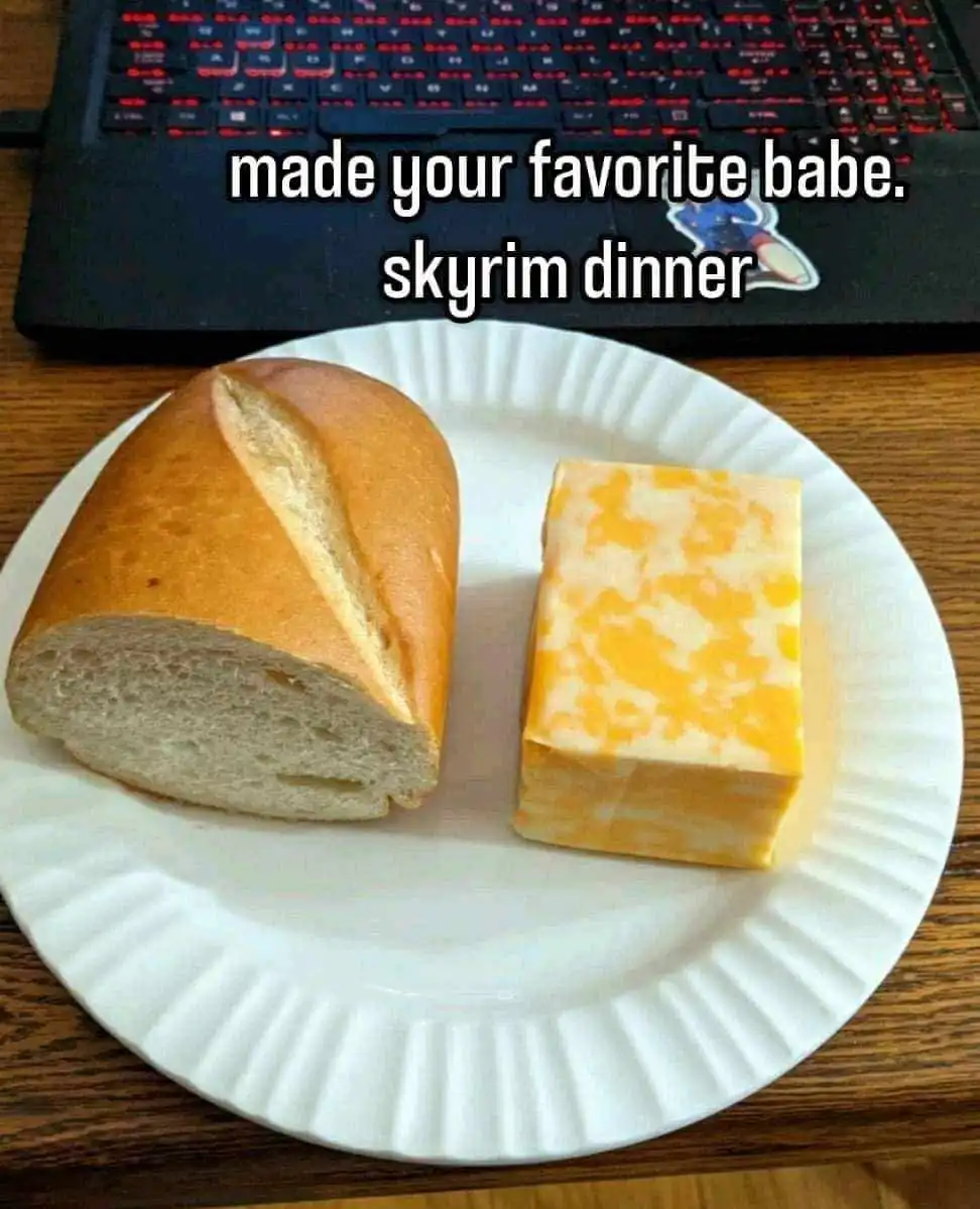 A white paper plate holds a half of a loaf of bread and a block of yellow cheese, placed on a wooden surface in front of a…